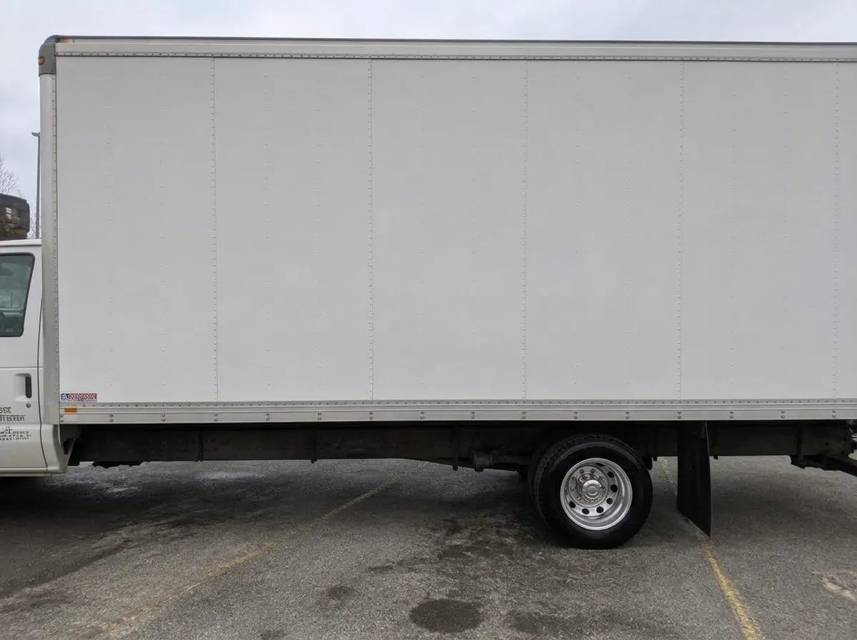 The same box truck panel washed clean and bright with polished wheel